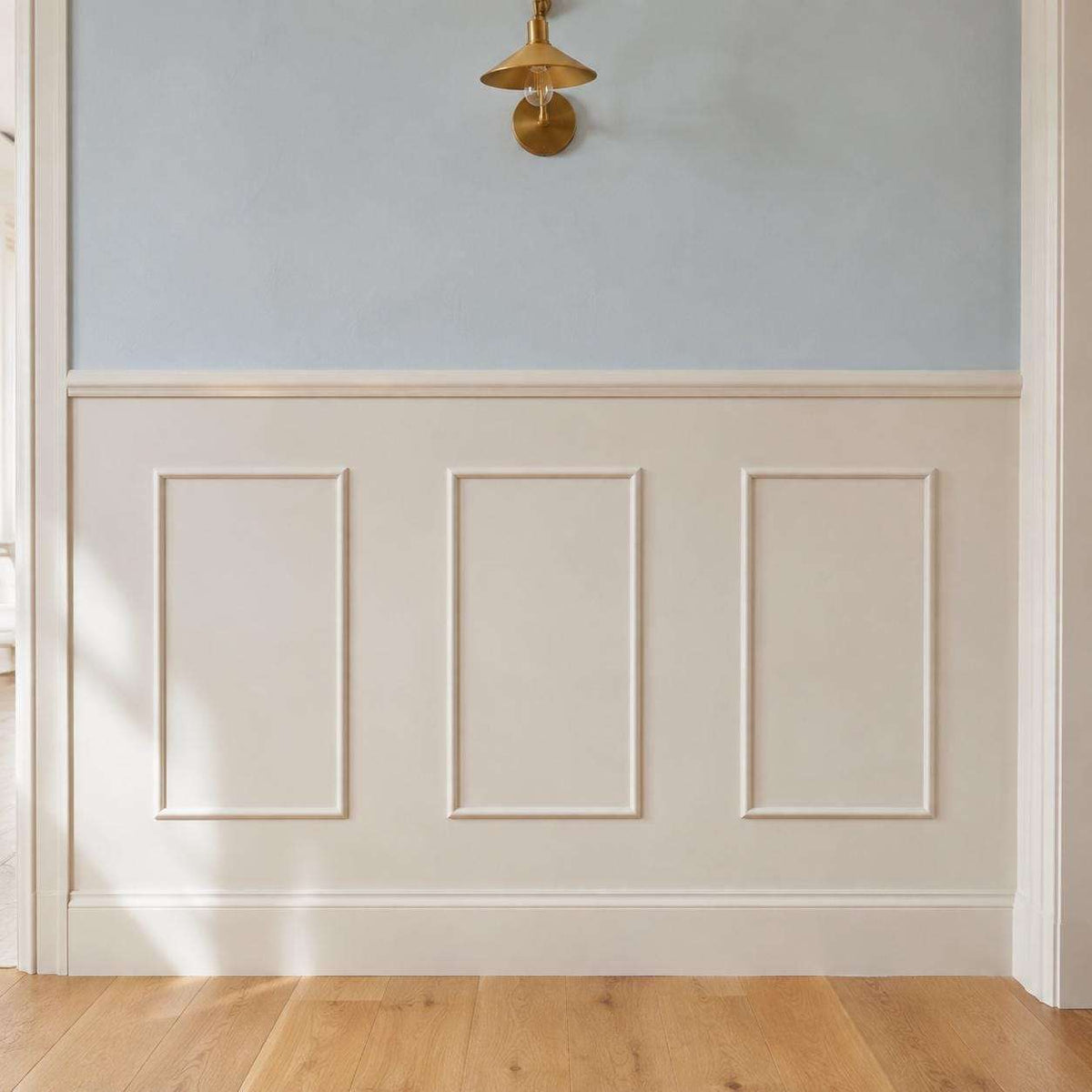 Half wall trim idea: cream half wall picture frame wainscoting in a hallway